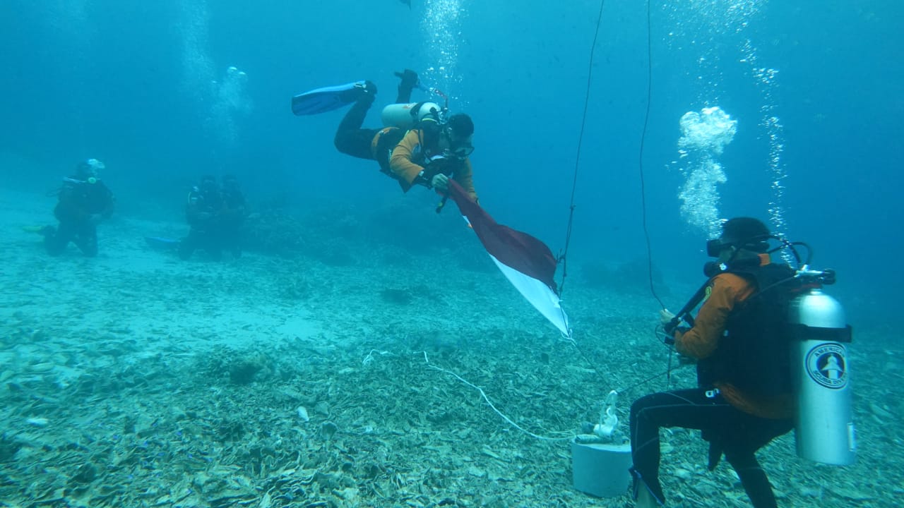 Personel Basarnas Ternate saat bertugas melakukan pengibaran merah putih di kedalaman 9 meter bawah laut Jikomalamo, Ternate.(Foto Basarnas).