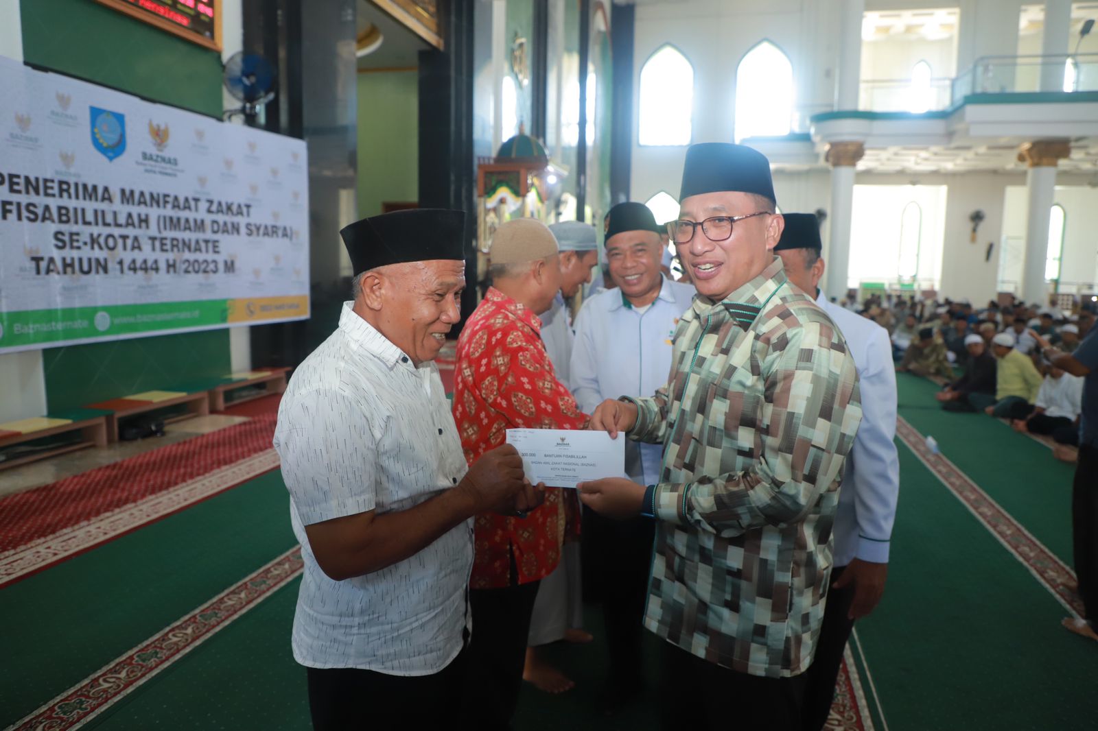 Wali Kota saat menyalurkan zakat kepada imam dan badan syara'a di Kota Ternate, Minggu 16 April 2023.(Istimewa).