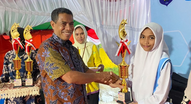 Kepala Dinas Pendidikan Kota Ternate Muslim Gani saat menyerahkan piala ke juara lomba budaya.(Foto : Istimewa).