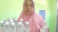 Koordinator Home Industri Oti Production Aida Usman saat memperlihatkan VCO hasil olahan warga.(Istimewa).