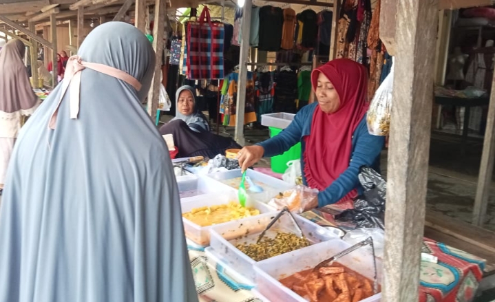 Ibu Ena, orang tua mantan casis Bambang Hadi saat menjajaki jualan sayur rebus di Pasar Malifut.(Foto : beritadetik.id).