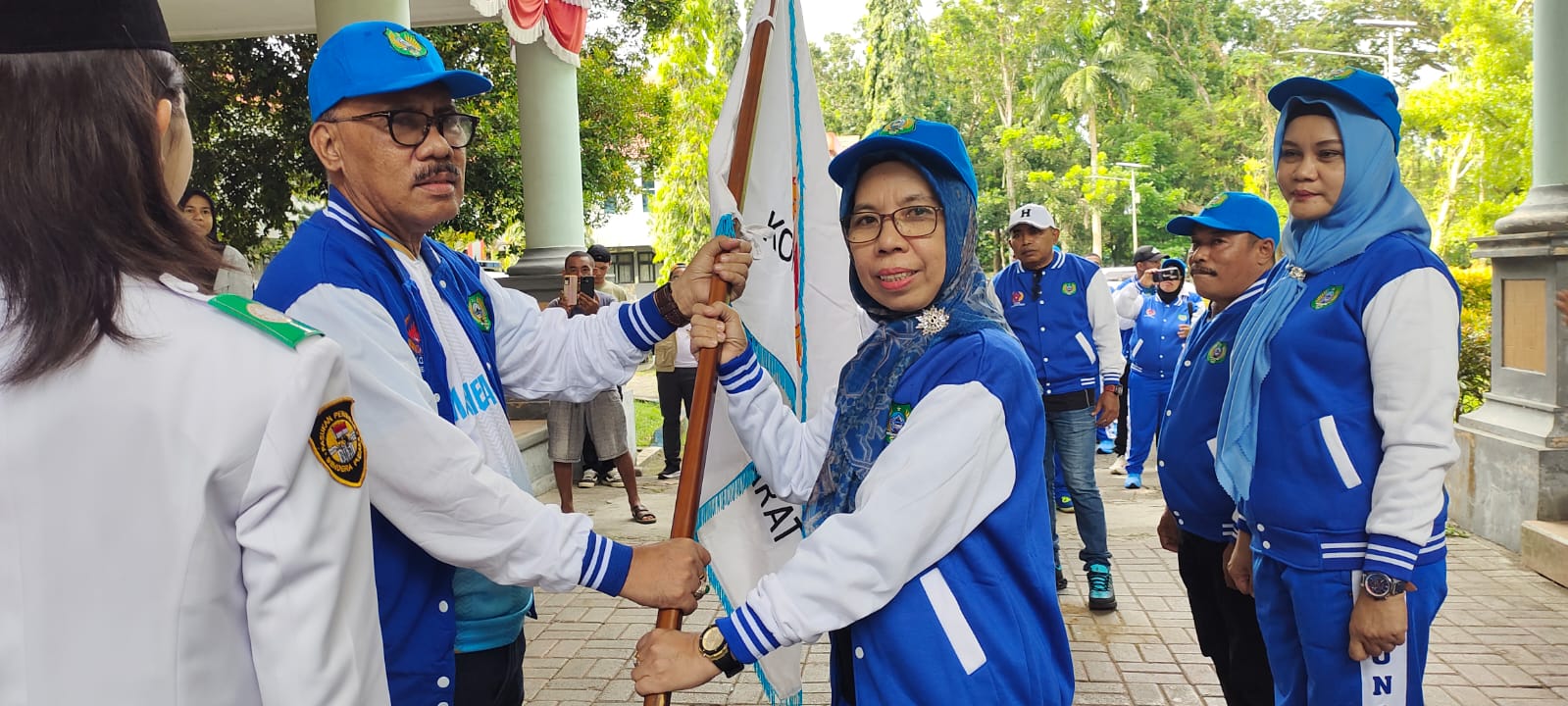 Bupati Halbar James Uang menyerahkan bendera pataka kepada Ketua Kontingen, Hj. Chuzaemah Djauhar di halaman Kantor Bupati. (Istimewa)